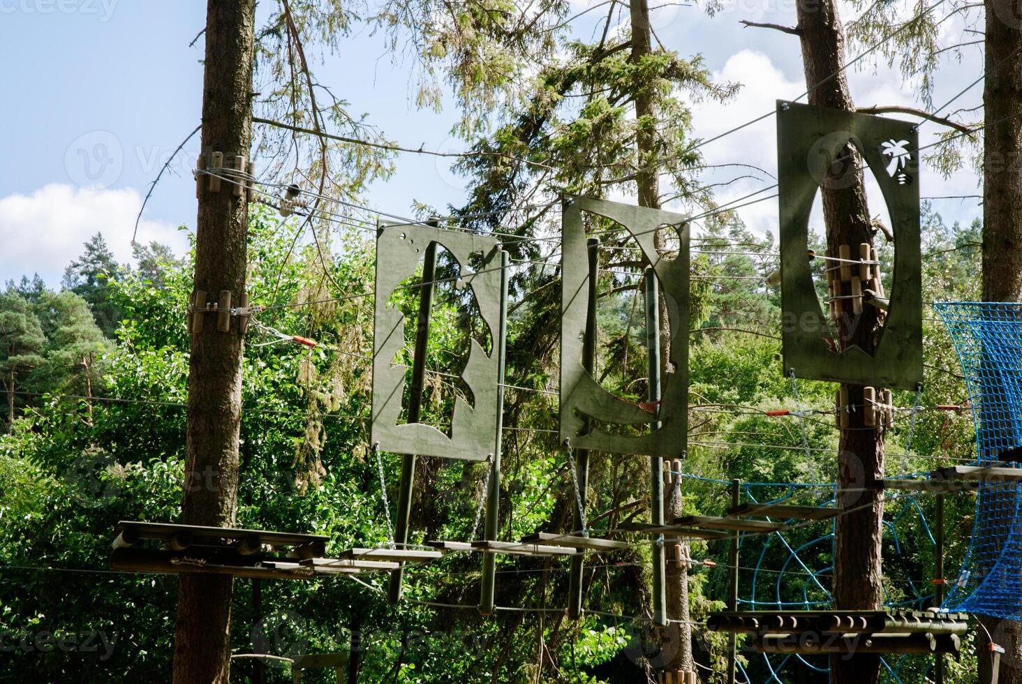 Adventure park ropes course in forest setting for recreational outdoor challenge. Weekend concept near the forest and lake photo