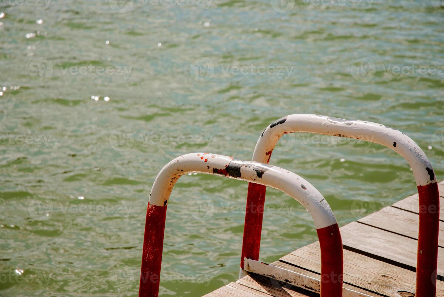 Tranquil lake dock scene with weathered metal handrails for relaxation and inspiration. Weekend concept near the forest and lake photo