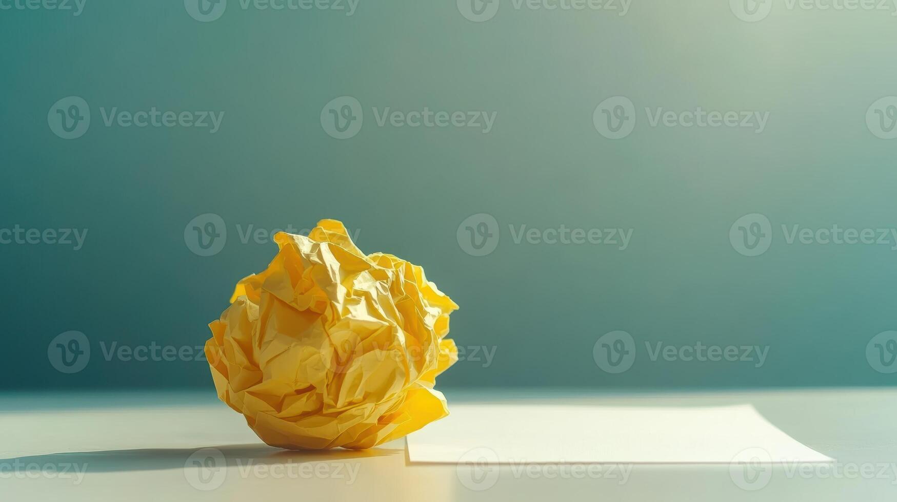 Crumpled yellow paper on a table against gradient background for minimalist design. Symbolism of fresh starts photo