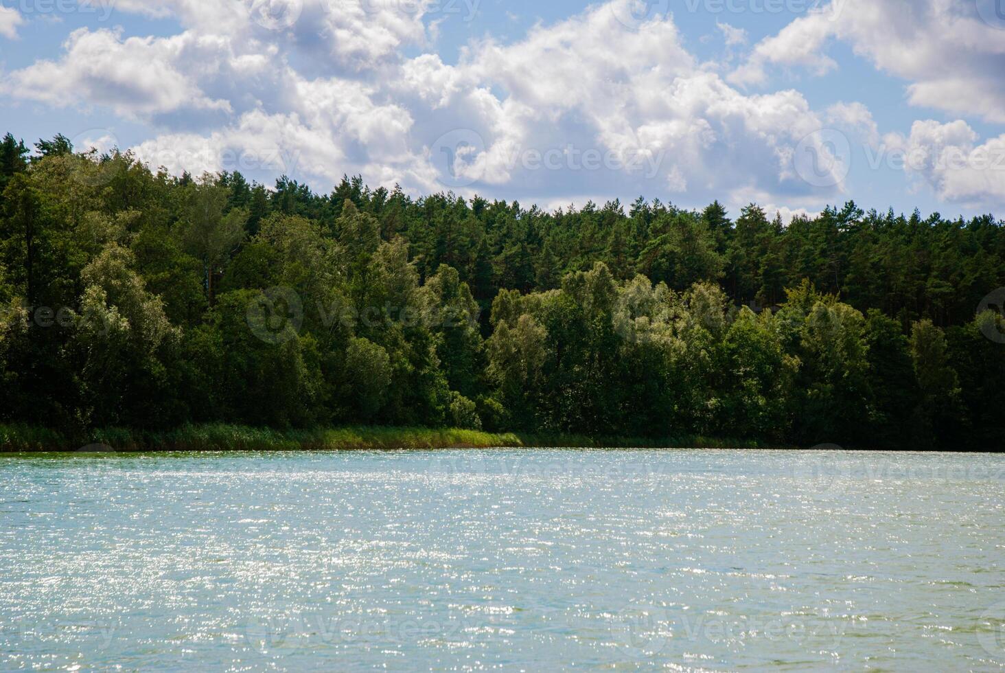 Tranquil summer lake with forest and cloudy sky - nature landscape for relaxation and inspiration. Weekend concept near the forest and lake photo