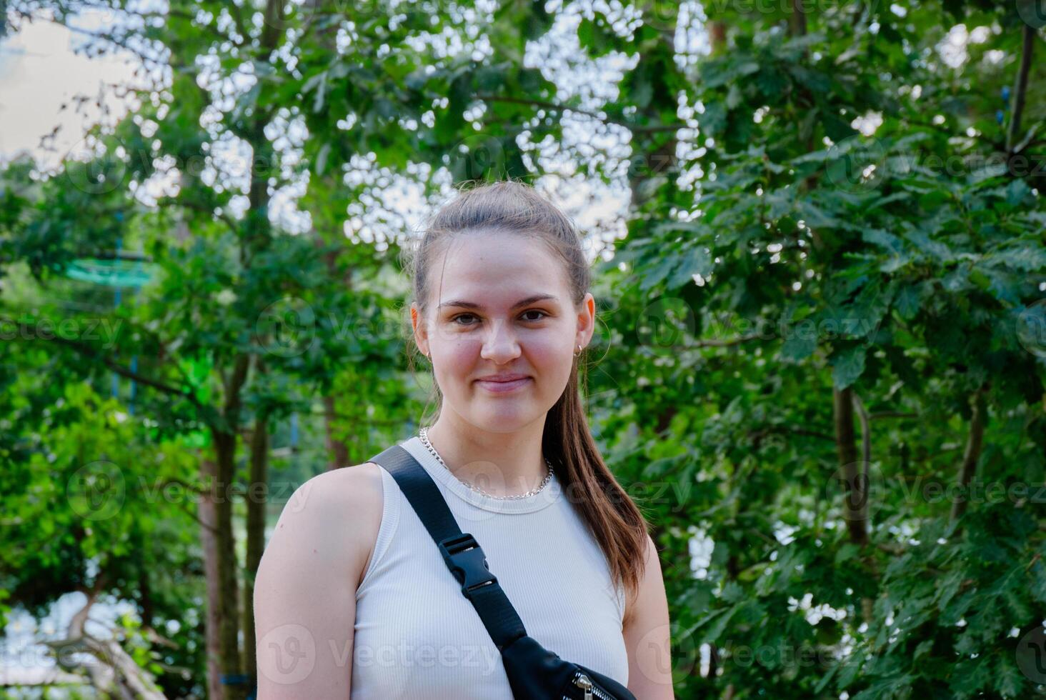 Young woman enjoying nature in a green forest setting. Weekend concept near the forest and lake photo