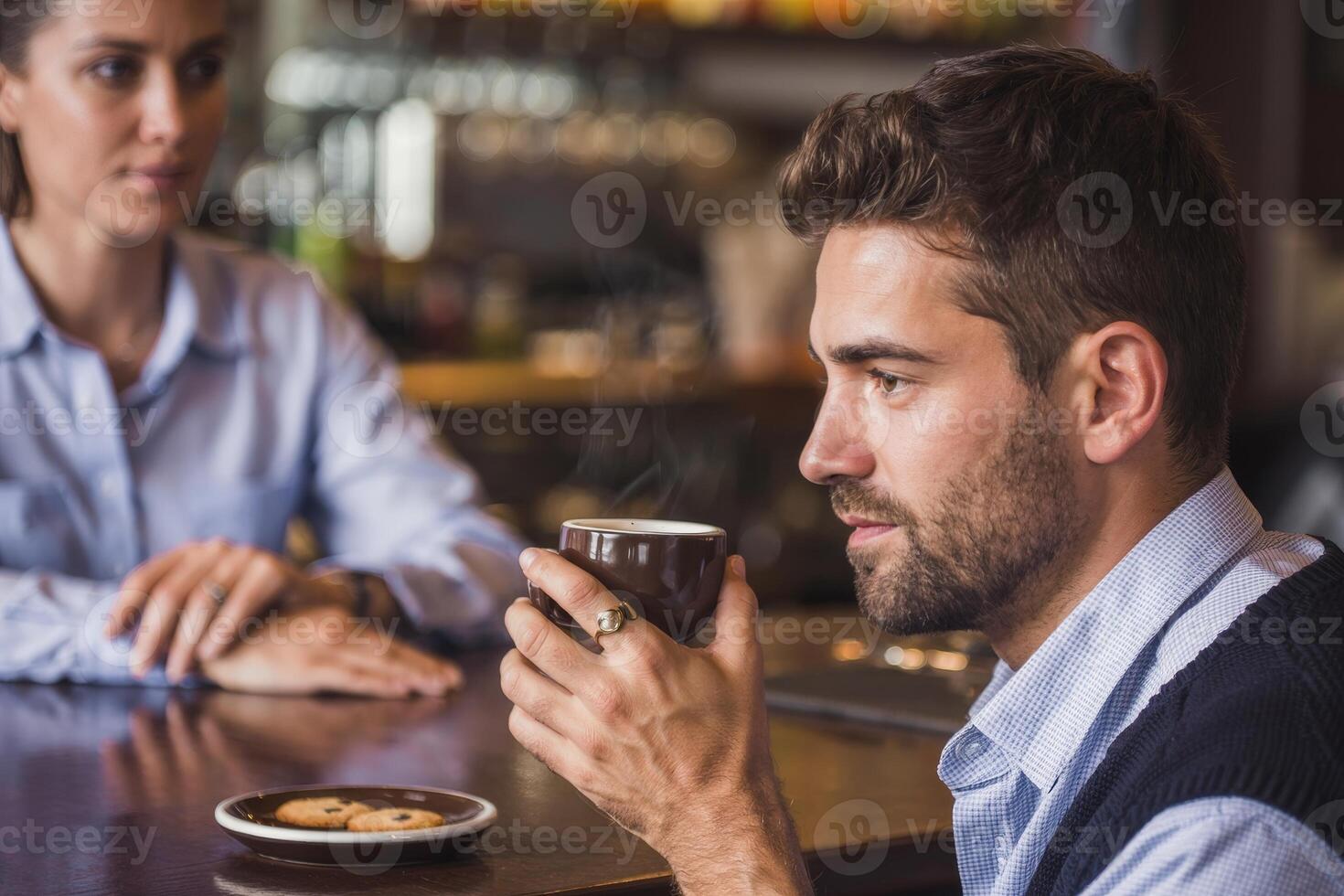 Young man enjoys a moment of peace with coffee and cookies at a busy bar in the afternoon photo