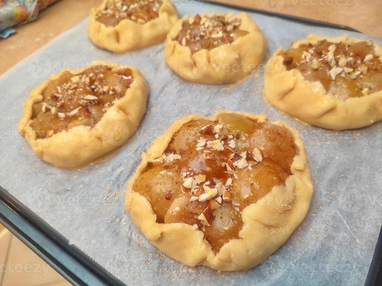 unbaked rustic apple galette with mascarpone and almonds arranged on baking paper before going into the oven photo