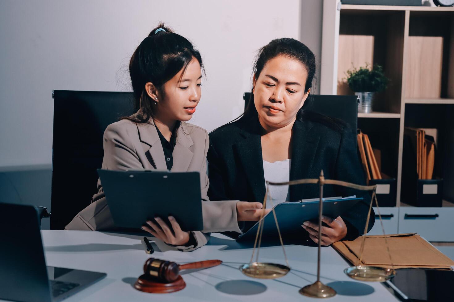 Two business women in a meeting room with a laptop and scales photo