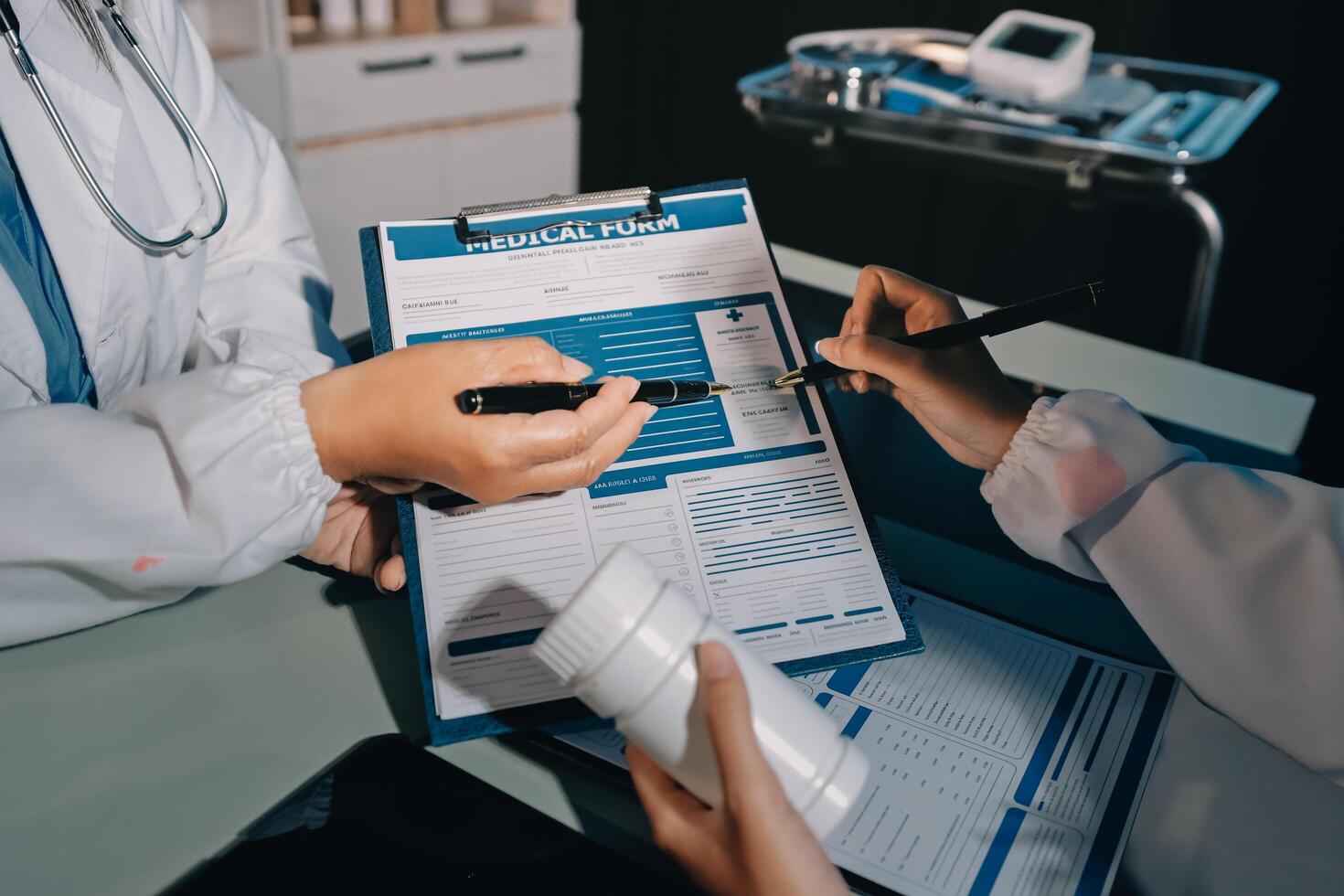 A doctor is holding a clipboard while another person is writing on it photo