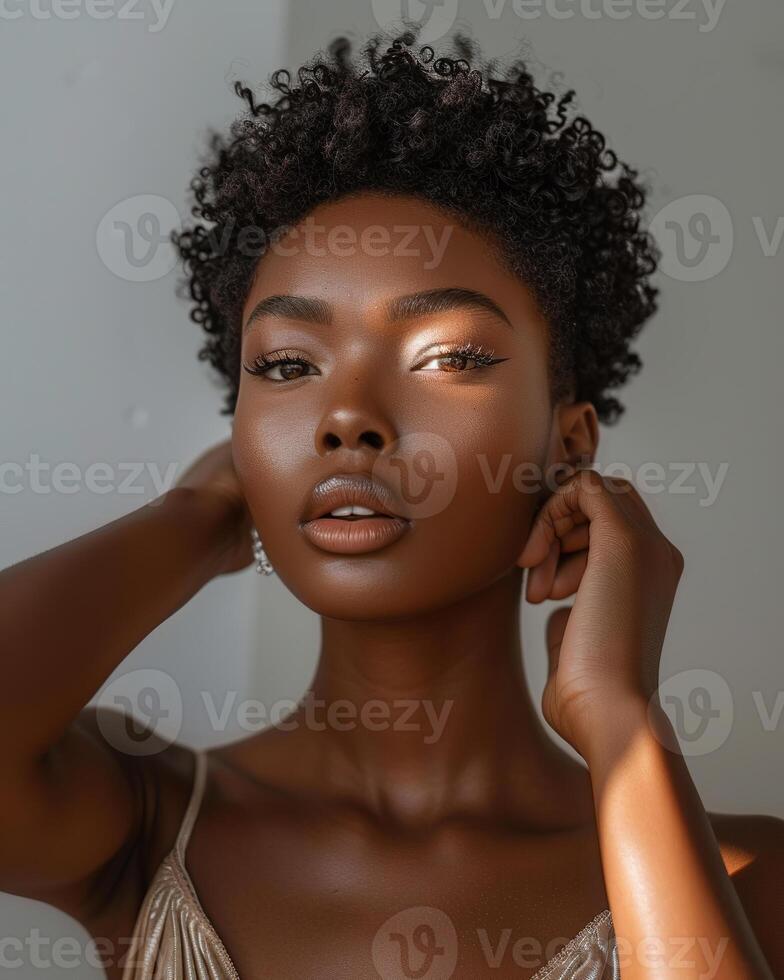 Dark skinned woman with natural curly hair posing confidently in soft light photo