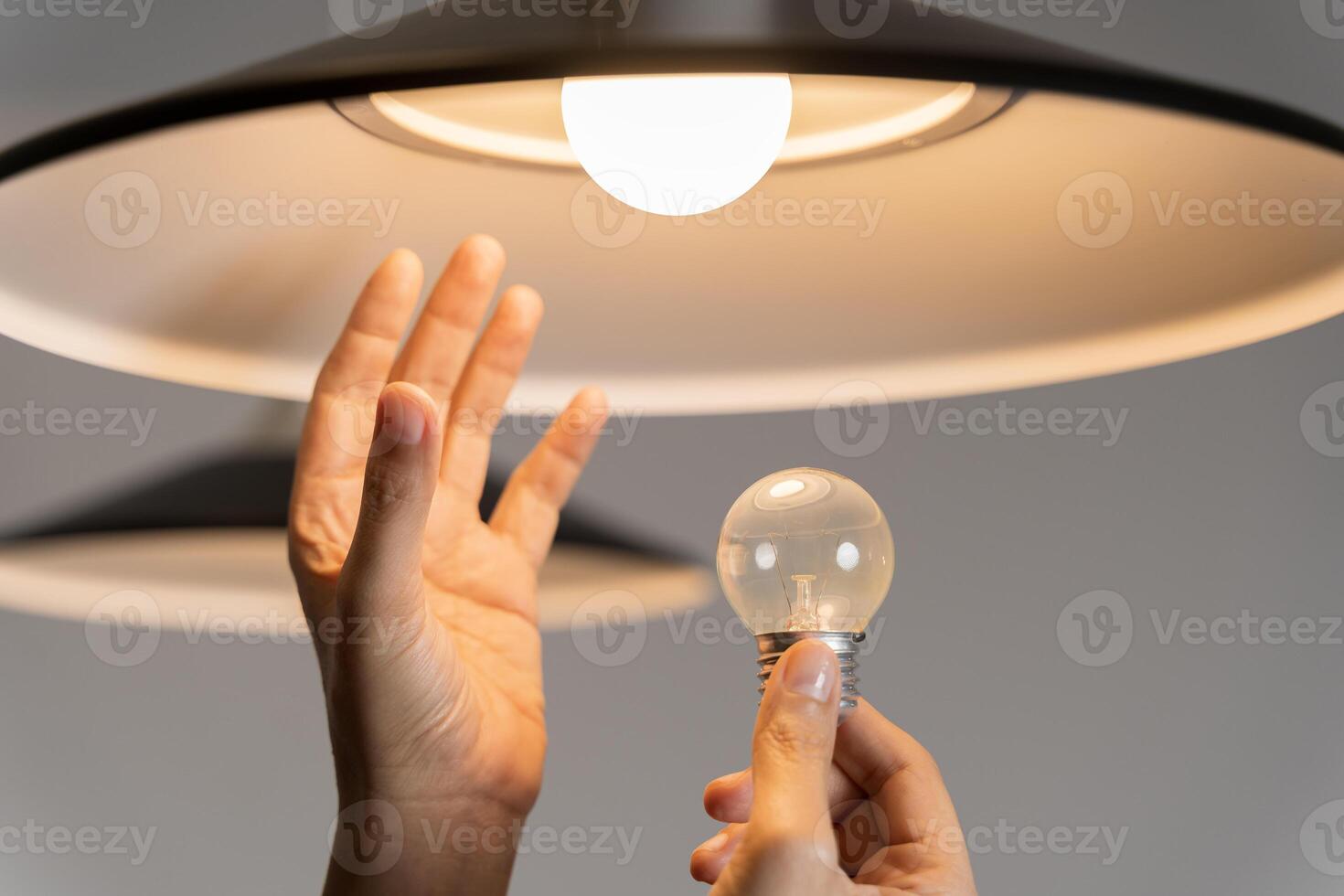 Changing Light Bulb. Man installs light fixture in new home. A man changes a light bulb in an apartment. photo