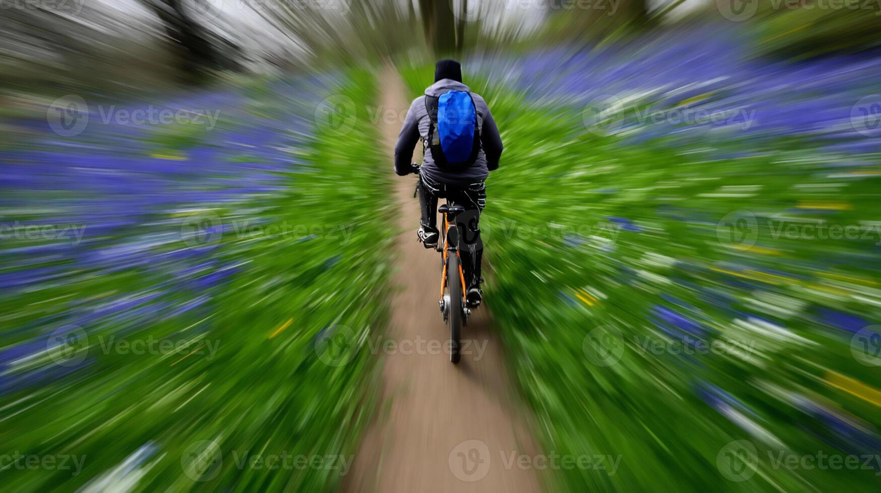 Biker navigating a lush path surrounded by vibrant blue and green flowers in a serene landscape during the morning hours photo