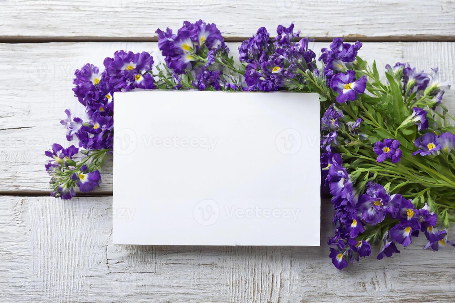 Bright purple flowers surround a blank white card for mockup on a rustic wooden table, creating a serene and inviting atmosphere perfect for wedding invitations photo