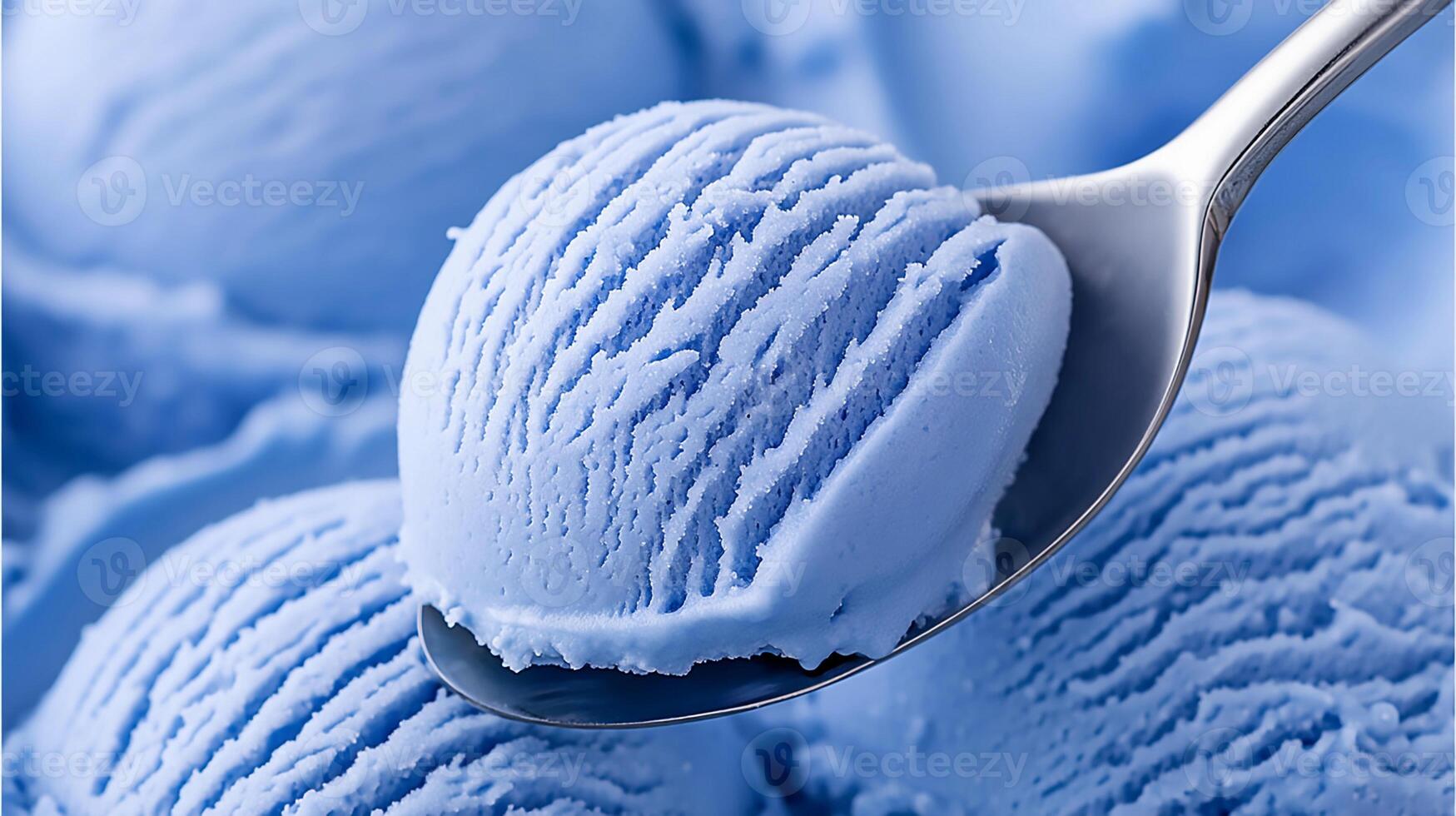 Blue ice cream scoop on a spoon against a backdrop of creamy ice cream in the bowl, showcasing the deliciousness and texture of the dessert while inviting indulgence photo