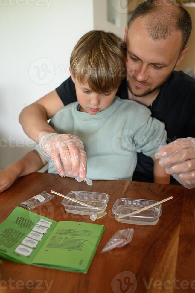 Smiling father teaches kids science through experiments at home. Bubbles, colors, and amazement bring excitement to the kitchen lab photo