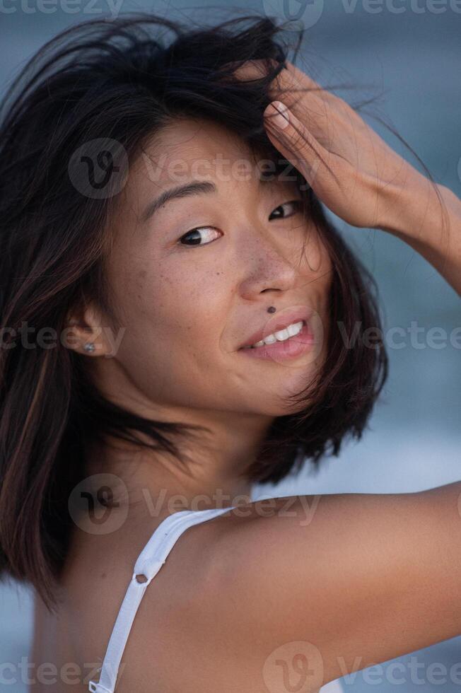 Wet strands frame her sharp features, lips parted slightly, eyes thoughtful. photo