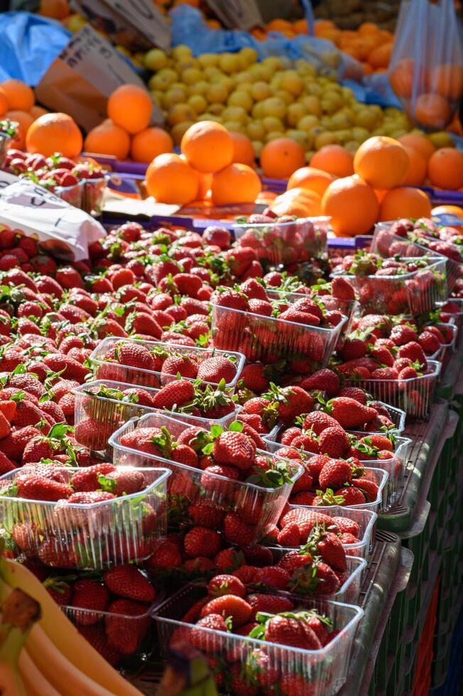 Fresh strawberries at a market, bright red and juicy, arranged in wooden baskets under the sunlight. photo