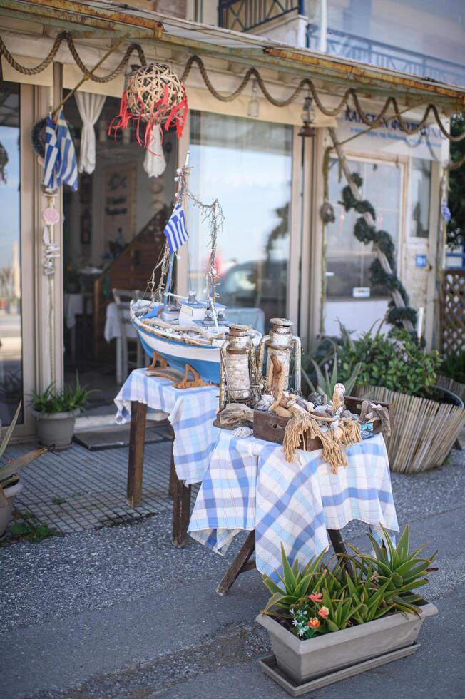 Traditional Greek cafe adorned with anchors, lifebuoys, and rustic lanterns, capturing the essence of the Aegean coast. photo