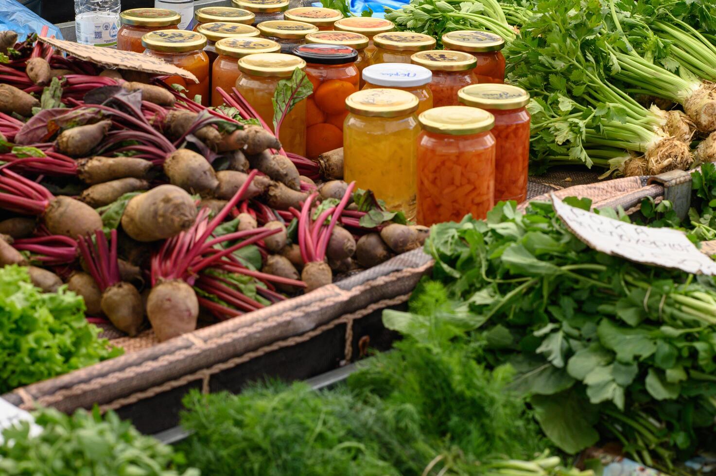 Handmade canned goods stacked beside baskets of fresh produce, highlighting farm-to-table freshness. photo
