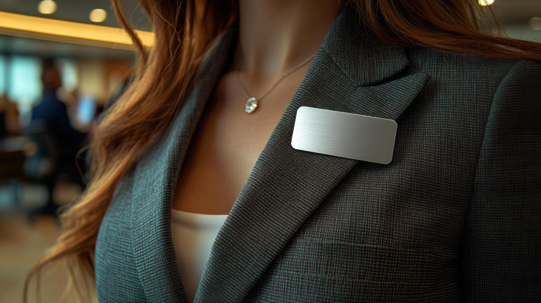 Professional woman in formal attire at a business event wearing a nametag while engaging with attendees during an evening networking session photo