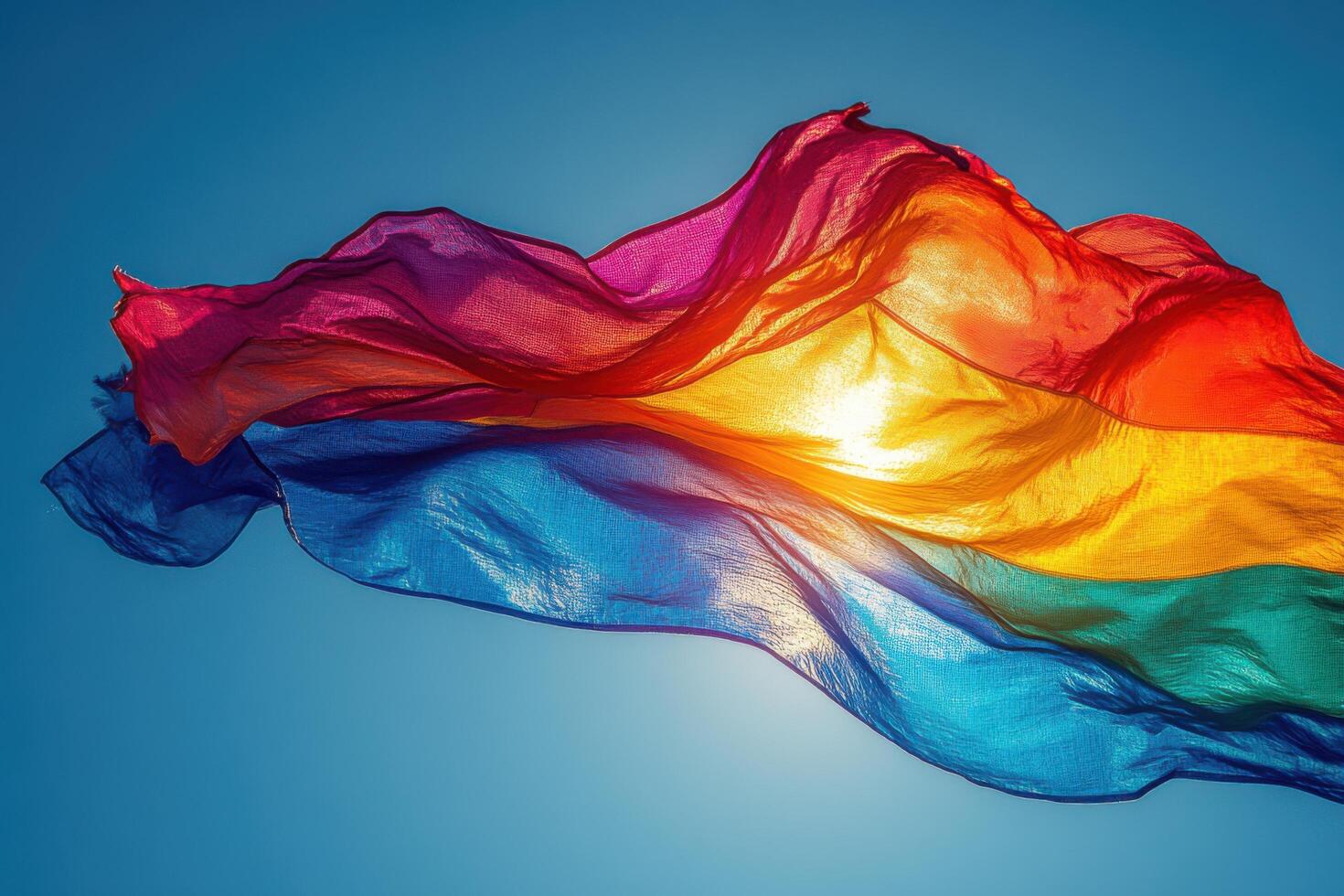 A rainbow colored flag flying in the wind photo