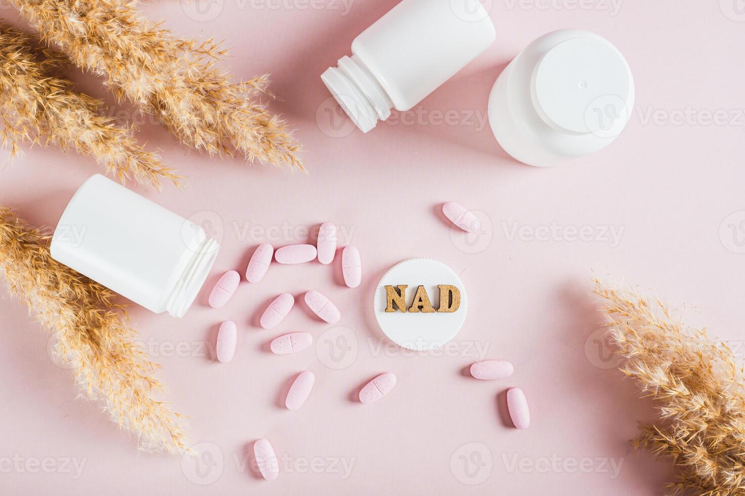 Nicotinamide adenine dinucleotide anti-aging pills and bottles on the table top view photo