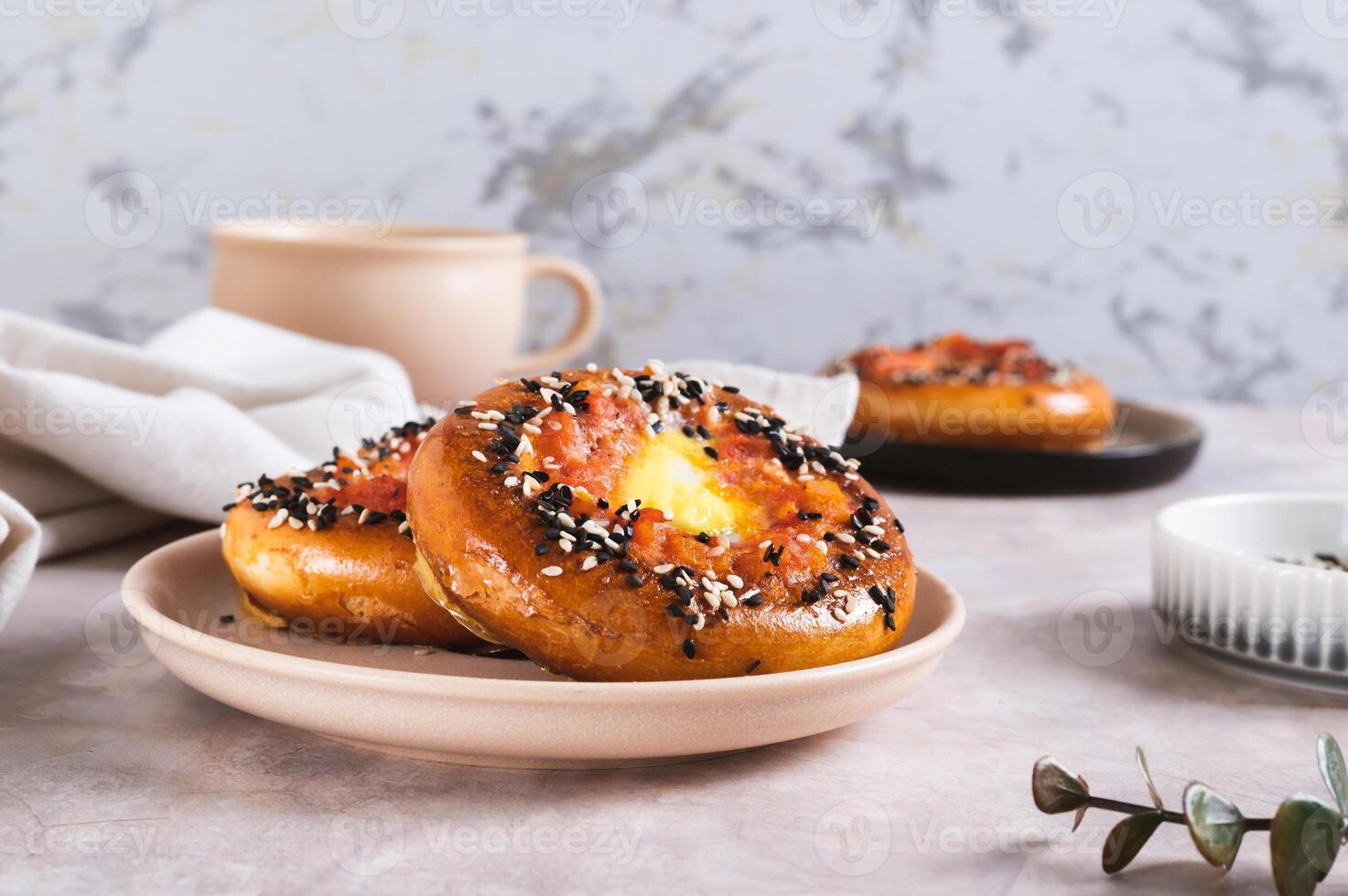 Baked bagels with tomato and quail egg on a plate on the table photo