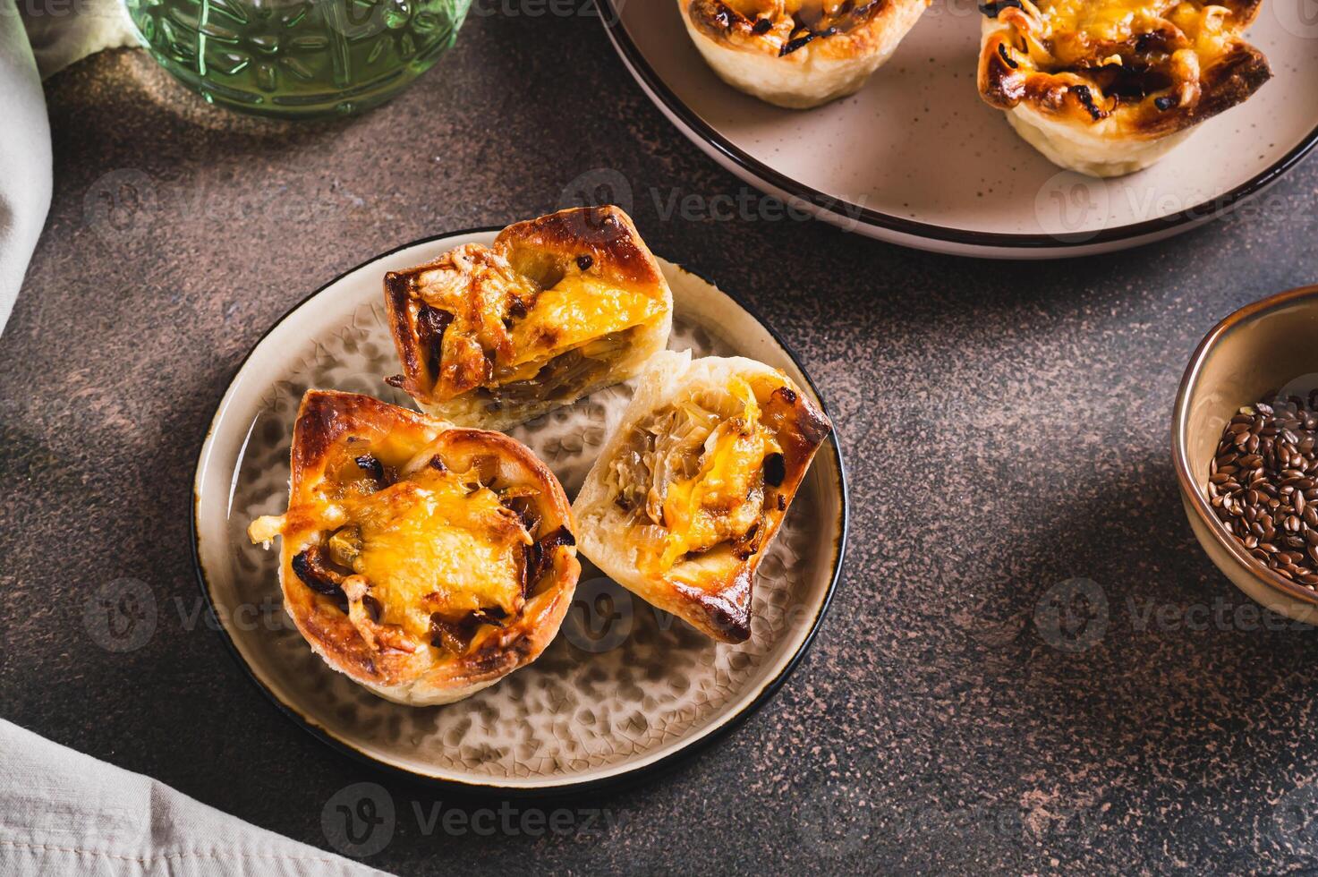 Homemade caramelized onion savory pies on a plate on the table photo