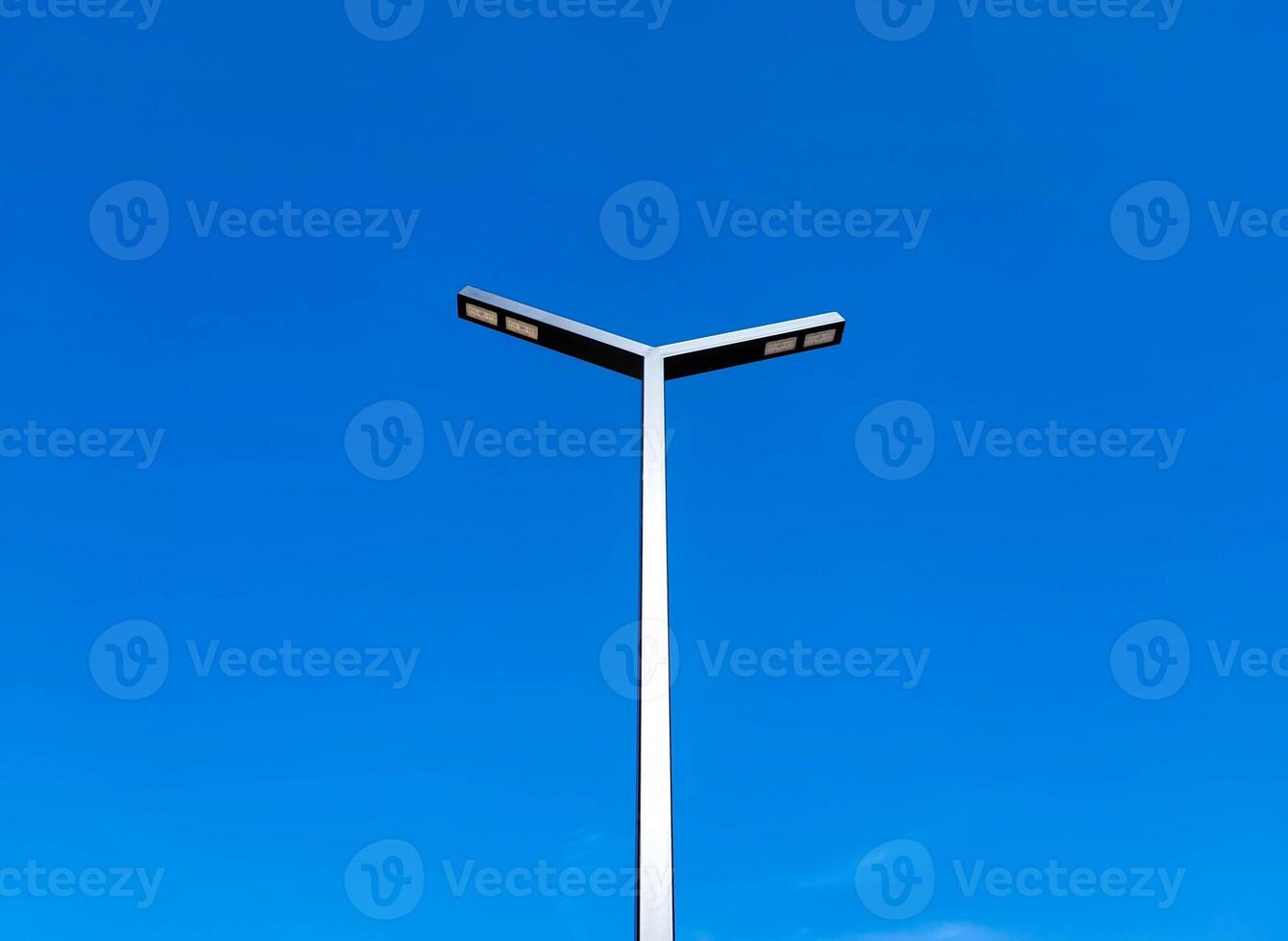 On the background of the blue sky, a pillar with rectangular lamps LED street lights. photo