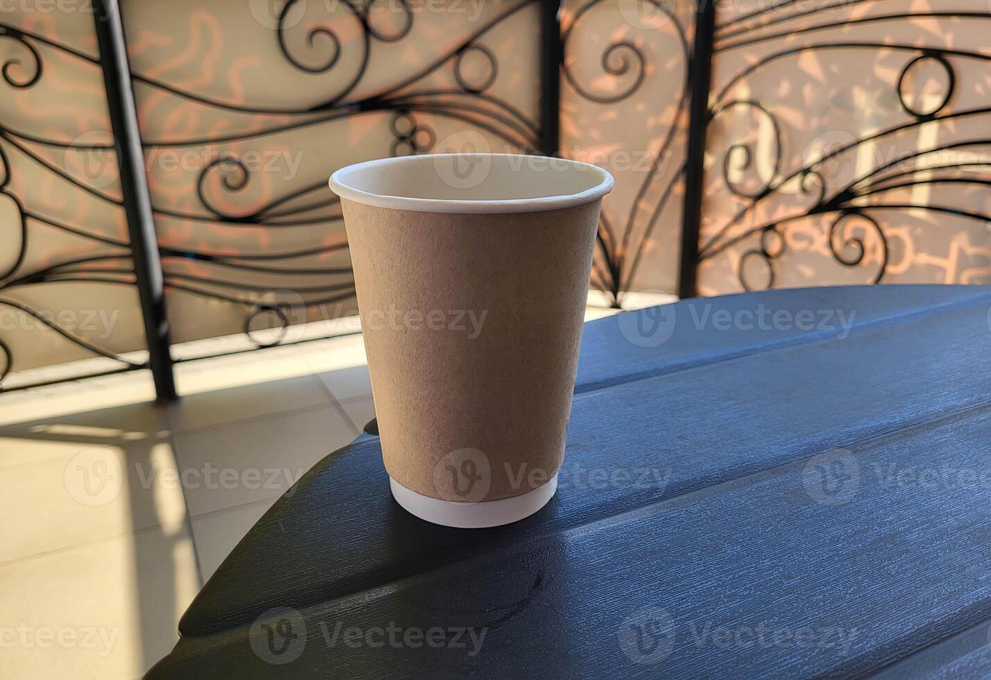 An empty brown paper coffee cup is on the table photo