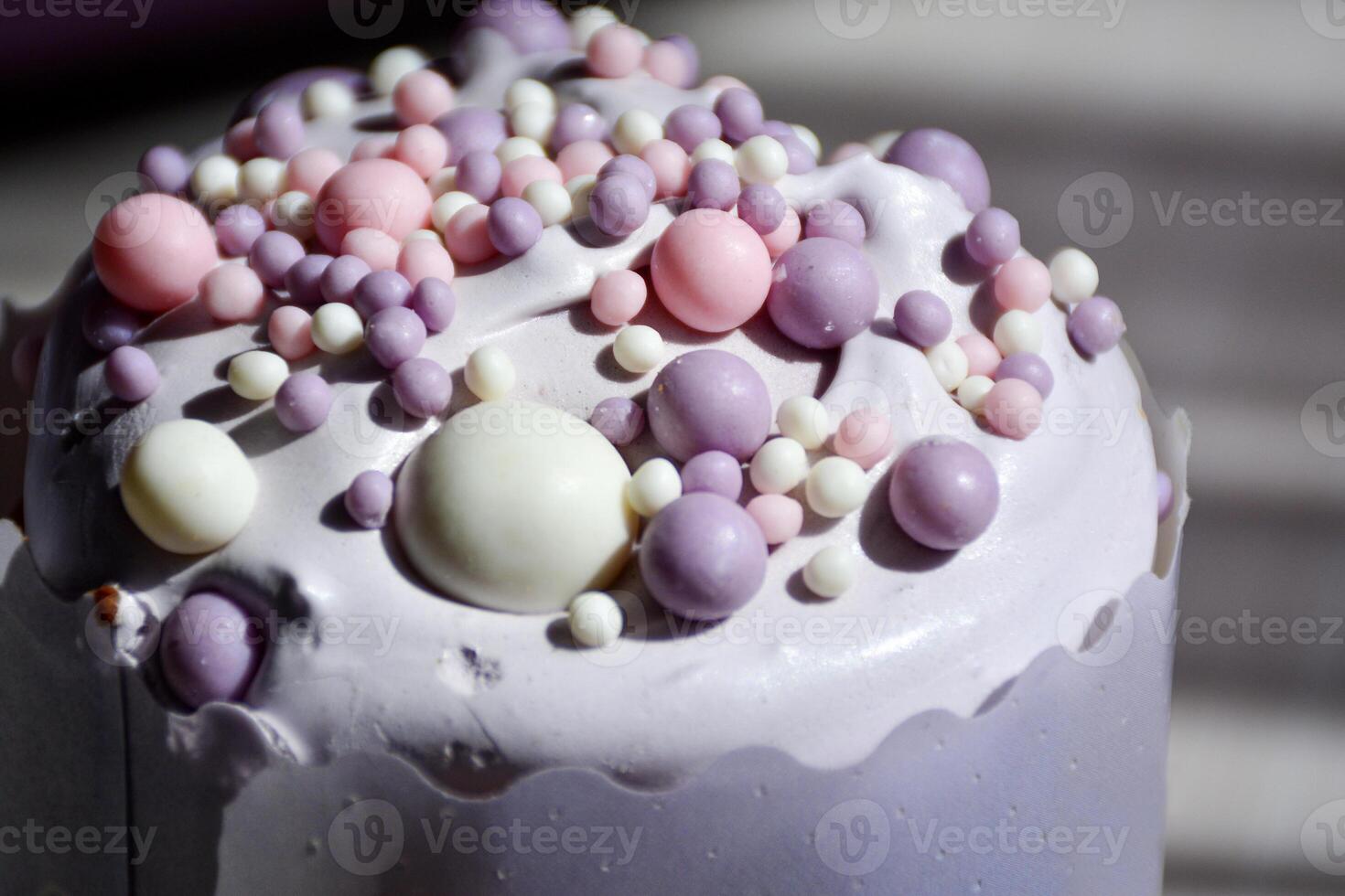 close up of a beautifully iced cake adorned with pastel-colored sprinkles. Smooth creamy icing with artistic arrangement of candy beads, creating a whimsical and inviting appearance. Eastern pastry photo