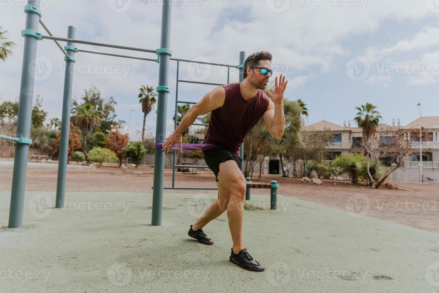 A man during a workout is training at an outdoor gym in a tropical location with palm trees photo