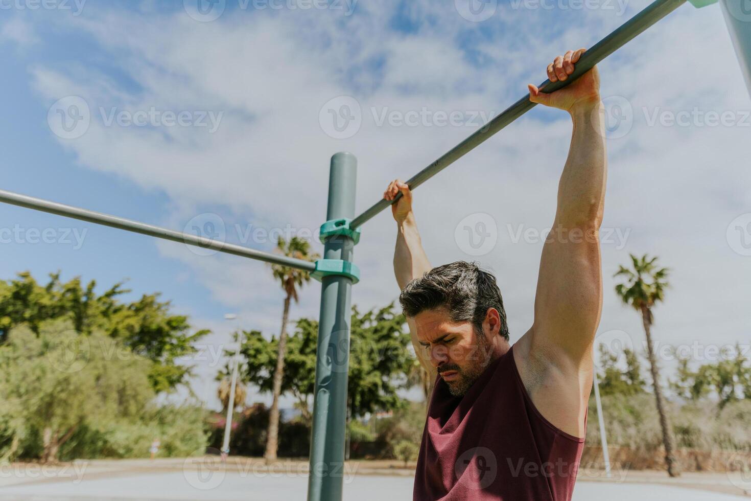 A man is holding a high bar at a calisthenics gym during a workout ready to do pull ups photo