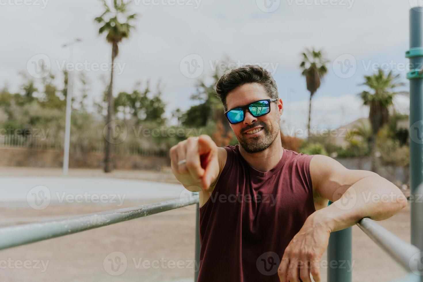 A fit 40 years old man points to the camera with his finger during a work-out, active lifestyle photo