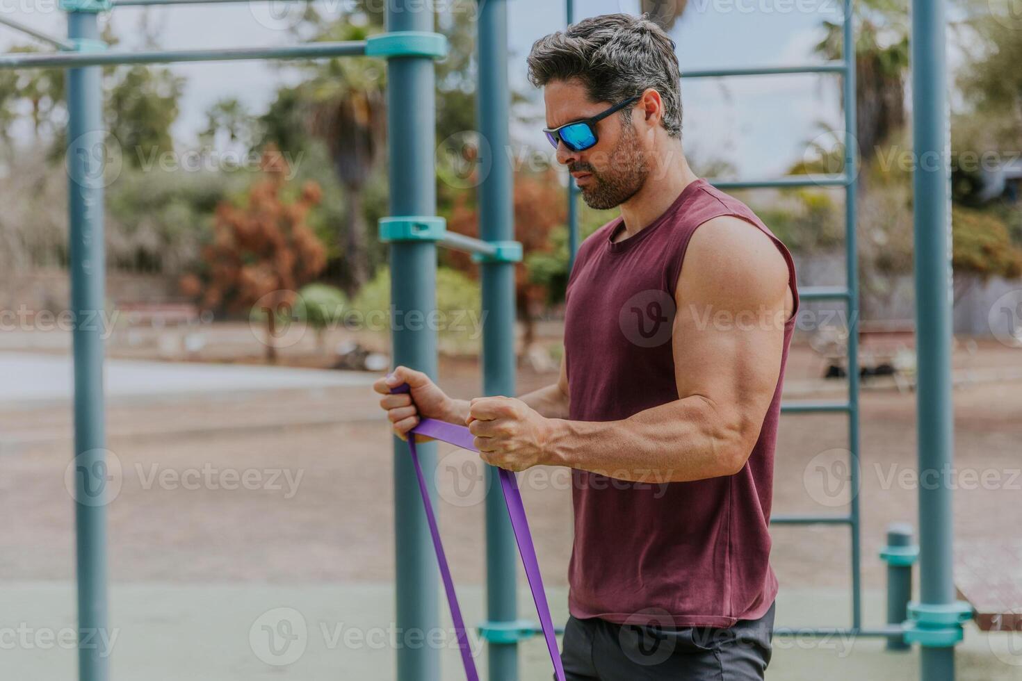 A muscular strong man is training at an outdoor gym, active lifestyle concept photo