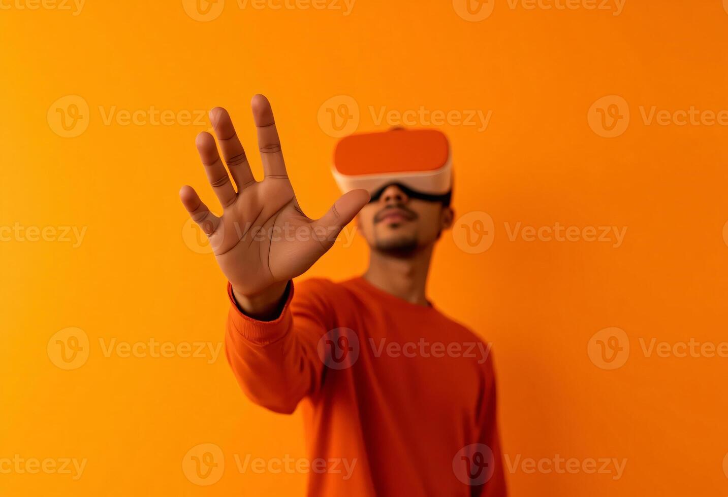 A person wearing a futuristic orange-tinted VR headset, reaching into the foreground, Modern VR lifestyle, High-tech VR concept, Soft orange gradient background photo