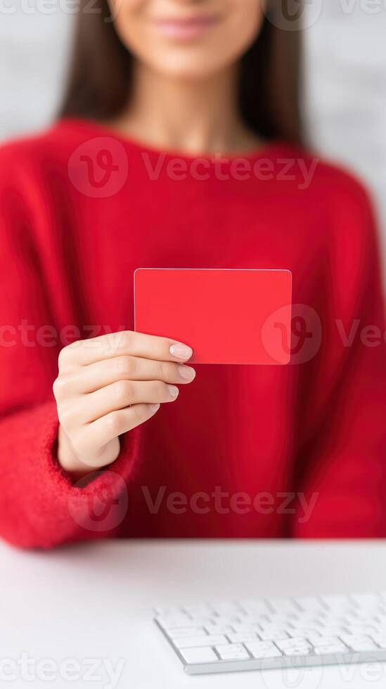 Woman holding a red card in front of a computer keyboard, showcasing a vibrant color contrast, modern workspace, creative concept, digital communication concept photo