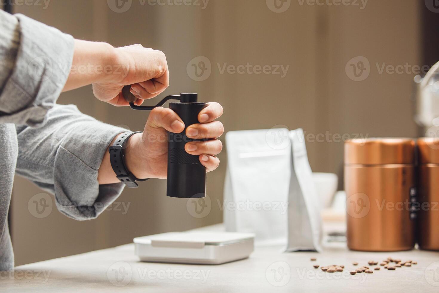 Barista Grinding Fresh Coffee Beans With Manual Grinder at Modern Cafe Counter photo