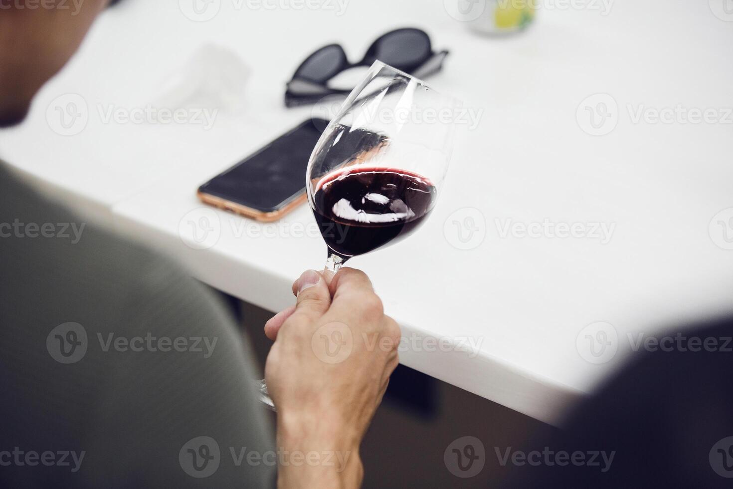 Portrait from the back of professional sommelier looking red wine and analysis color, close up shot. photo
