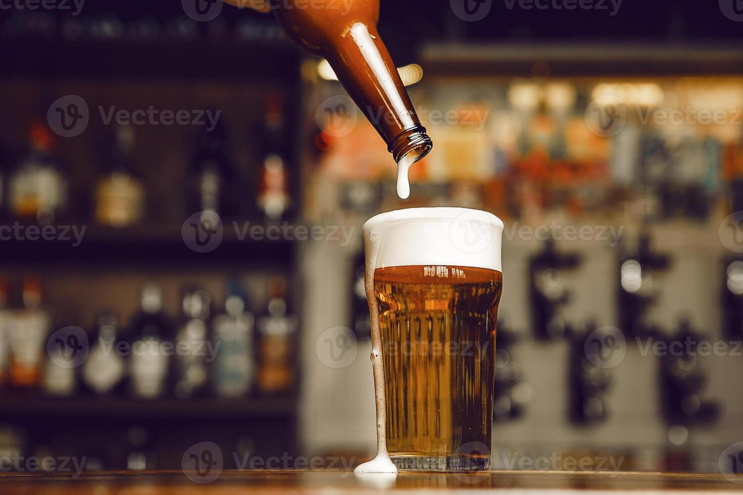 Pouring Cold Beer Into Glass With Rich Foam Topping at Bar Close up photo