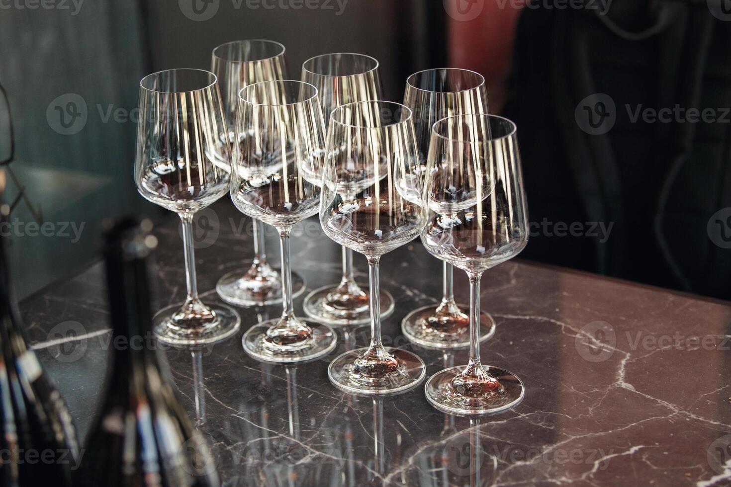 Few empty wine glasses on table near sparkling wine bottles. Wine tasting concept. photo
