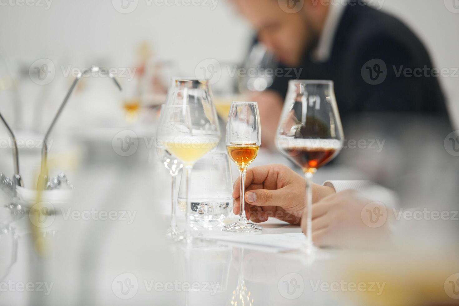 Blind tasting, close up. Sommelier makes notes on the tasting card. photo
