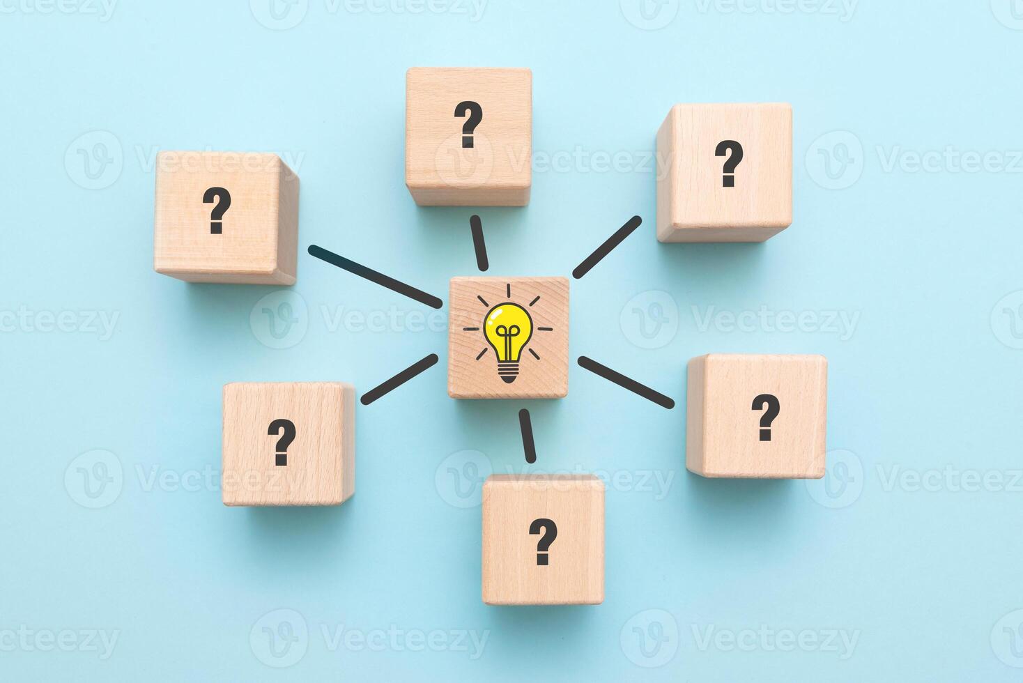 Wooden blocks with question marks and light bulb on blue background photo