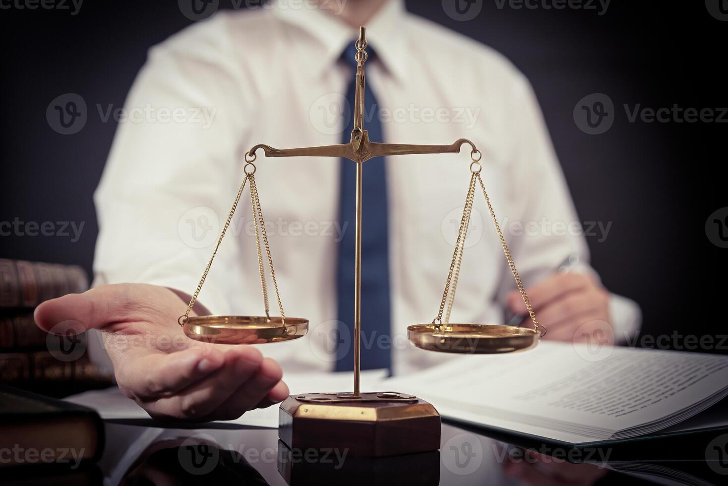 A man holding a scale of justice in front of a book photo