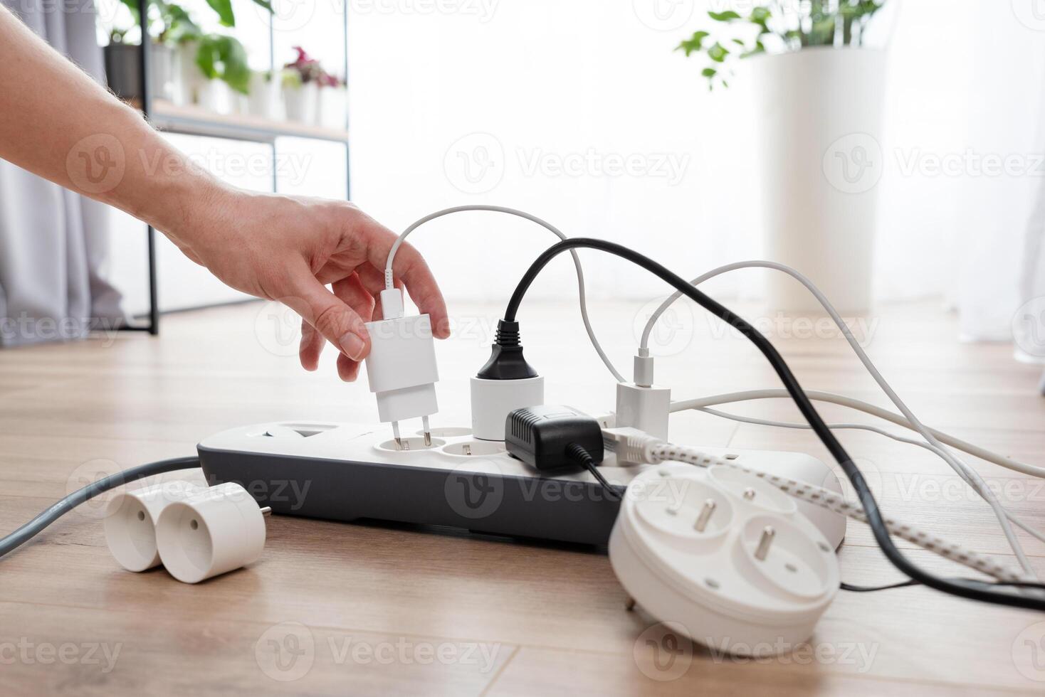 A person is plugging in a power strip photo