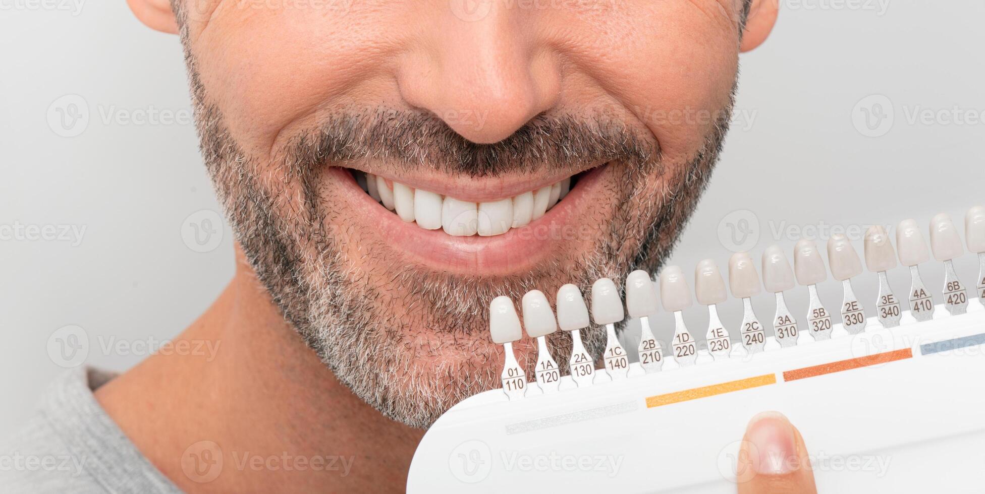 A man is smiling while holding a toothbrush photo