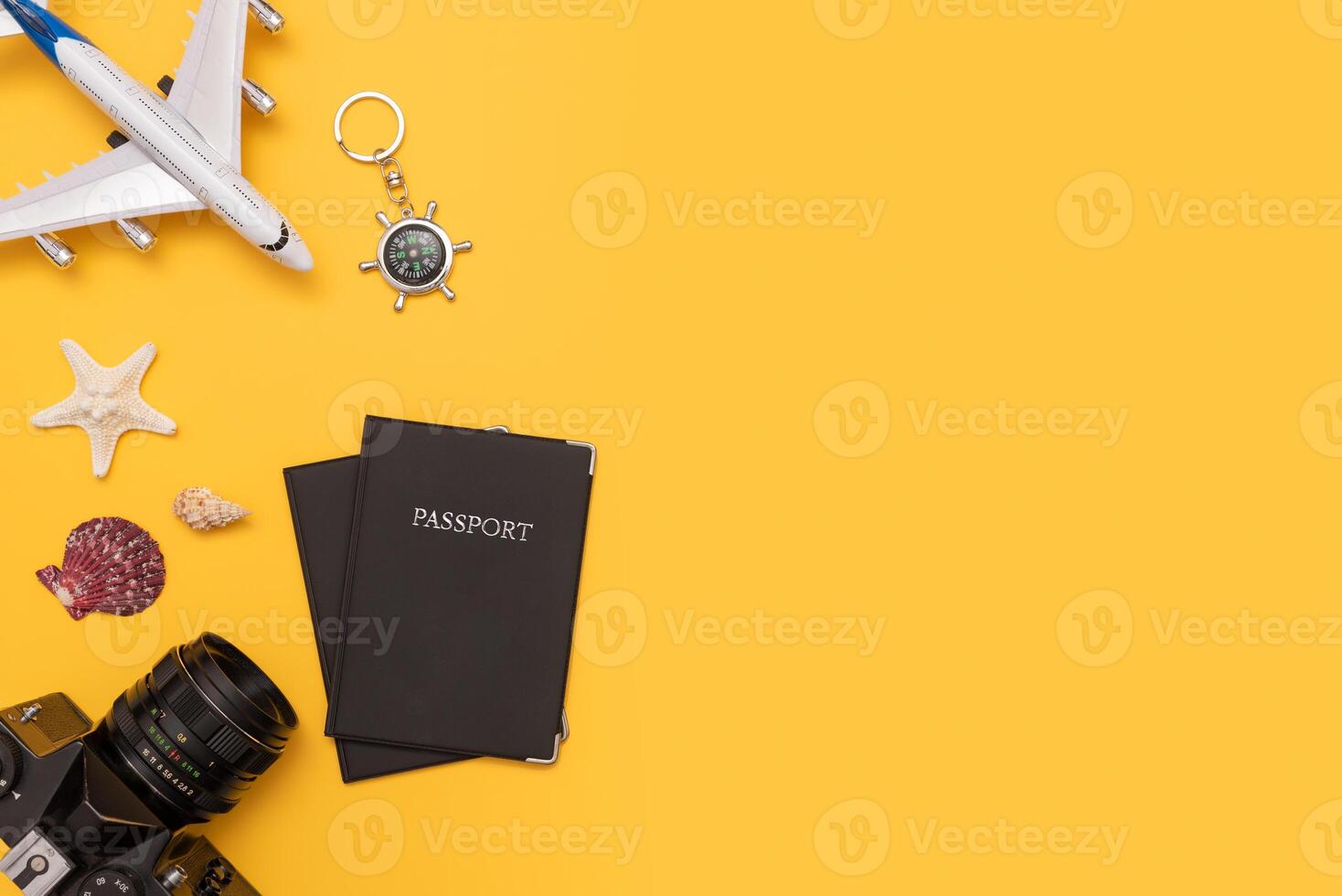 Travel concept with passport, camera, starfish, and other travel accessories on yellow background flat lay photo