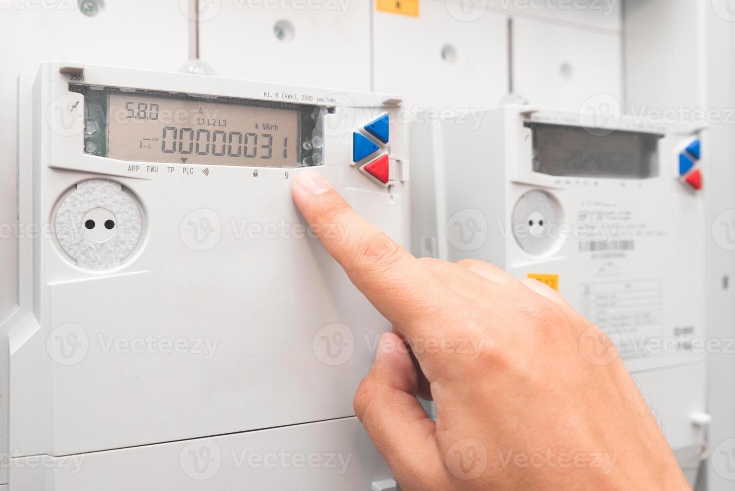 A person is touching a meter on a wall photo