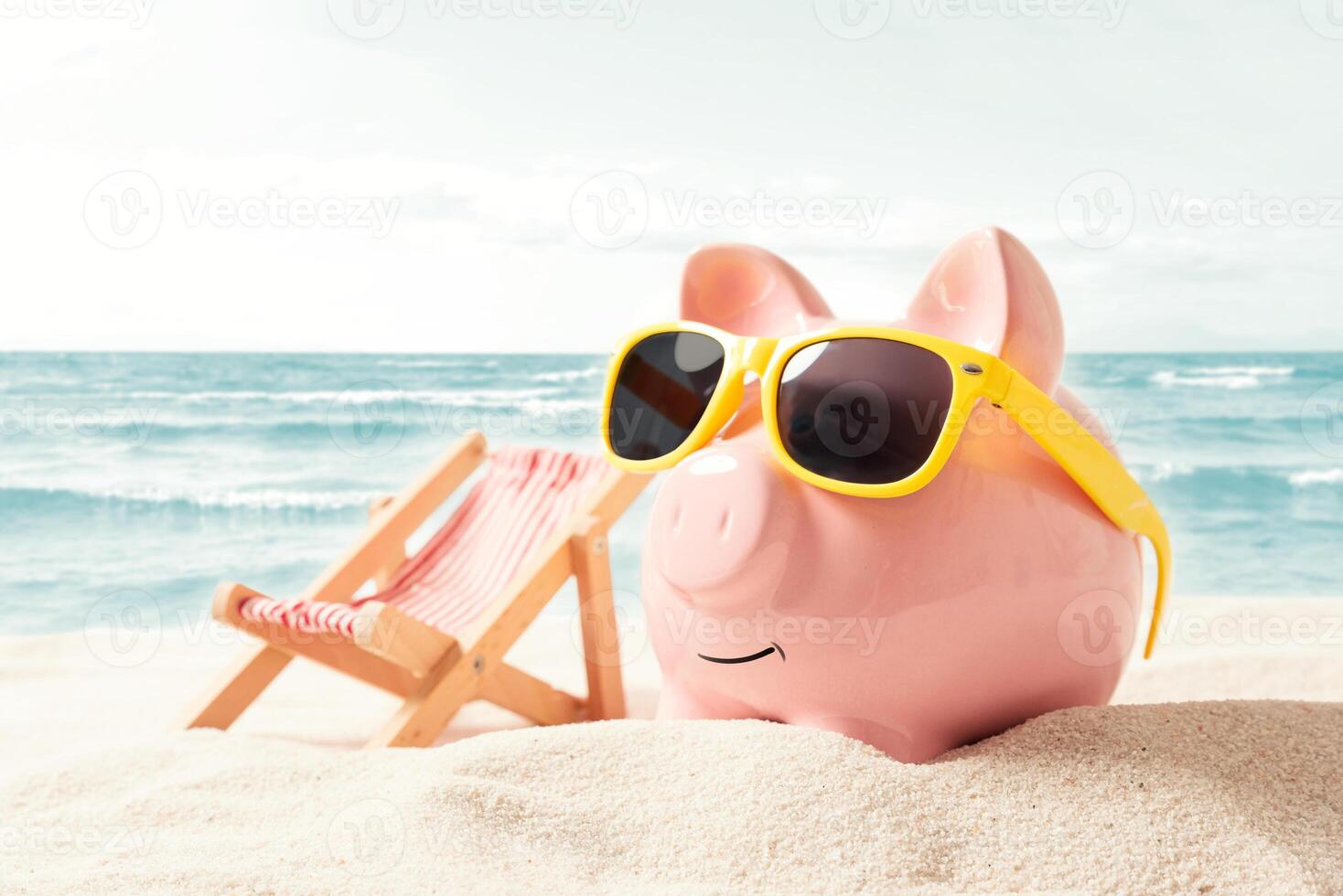 Piggy bank with sunglasses on beach with beach chair and beach towel photo