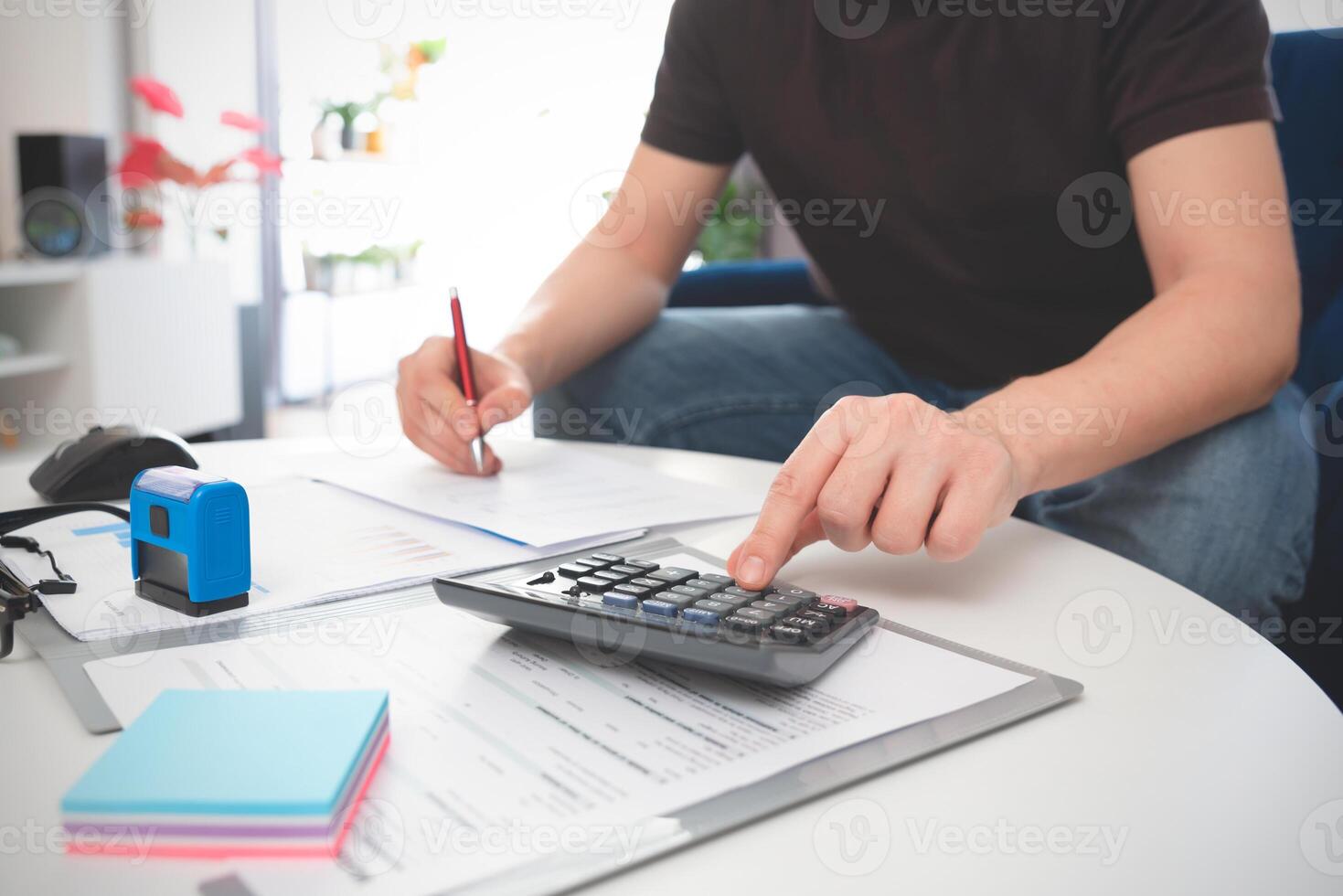A man is using a calculator to do some math photo