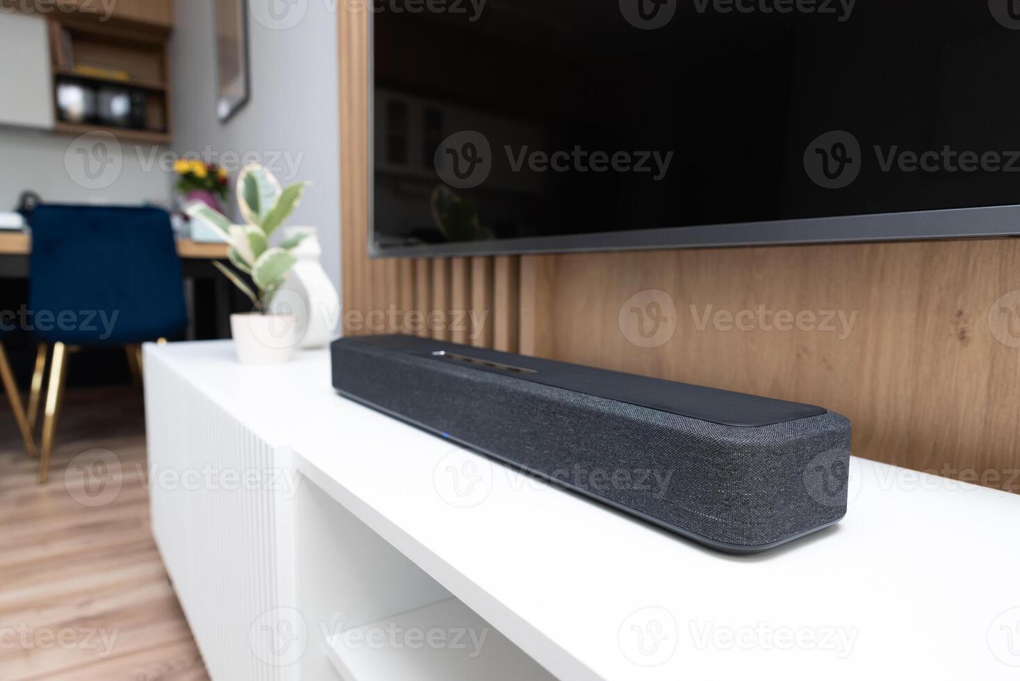 A sound bar is sitting on a white shelf photo