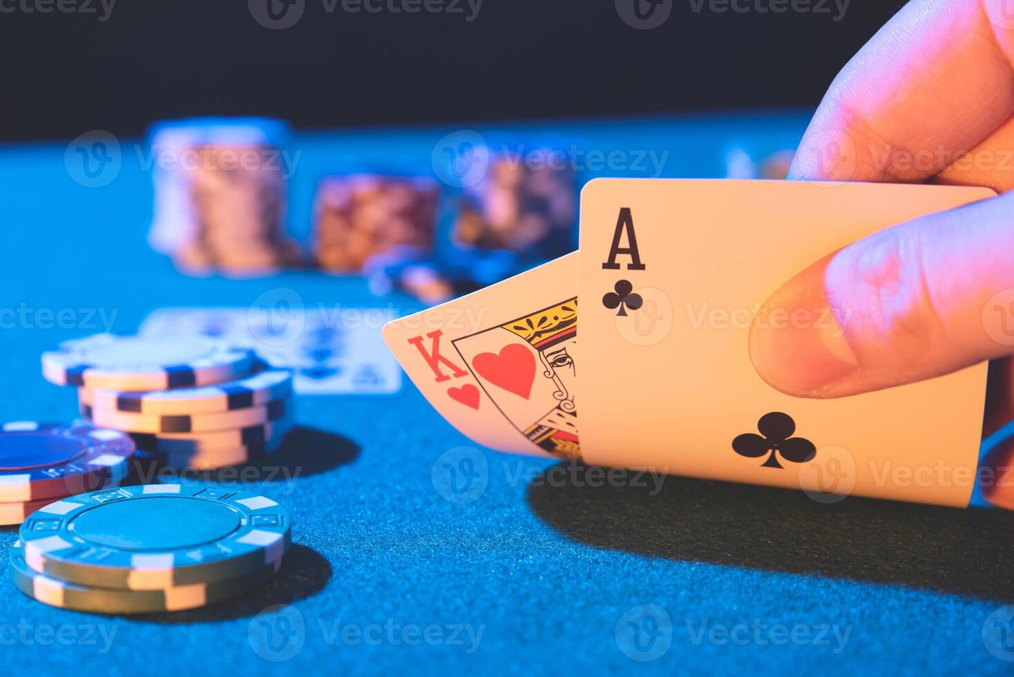 A hand holding a card and playing cards on a table photo