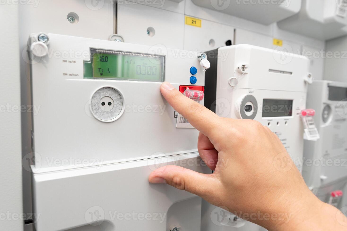 A person is touching a control panel on a wall photo