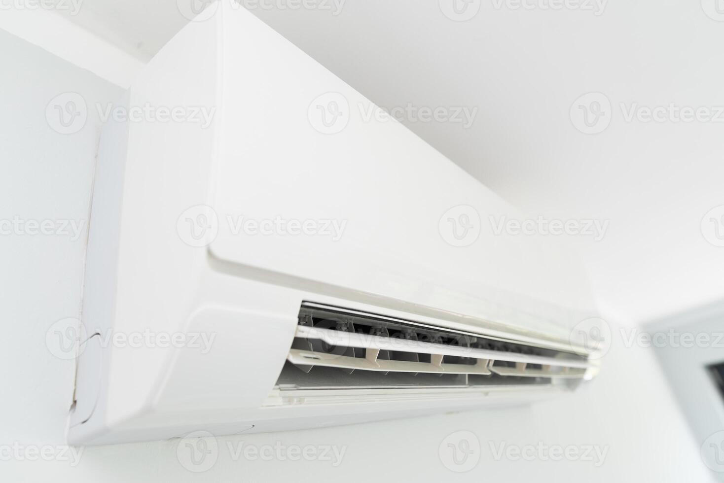 A white air conditioner mounted on a wall photo